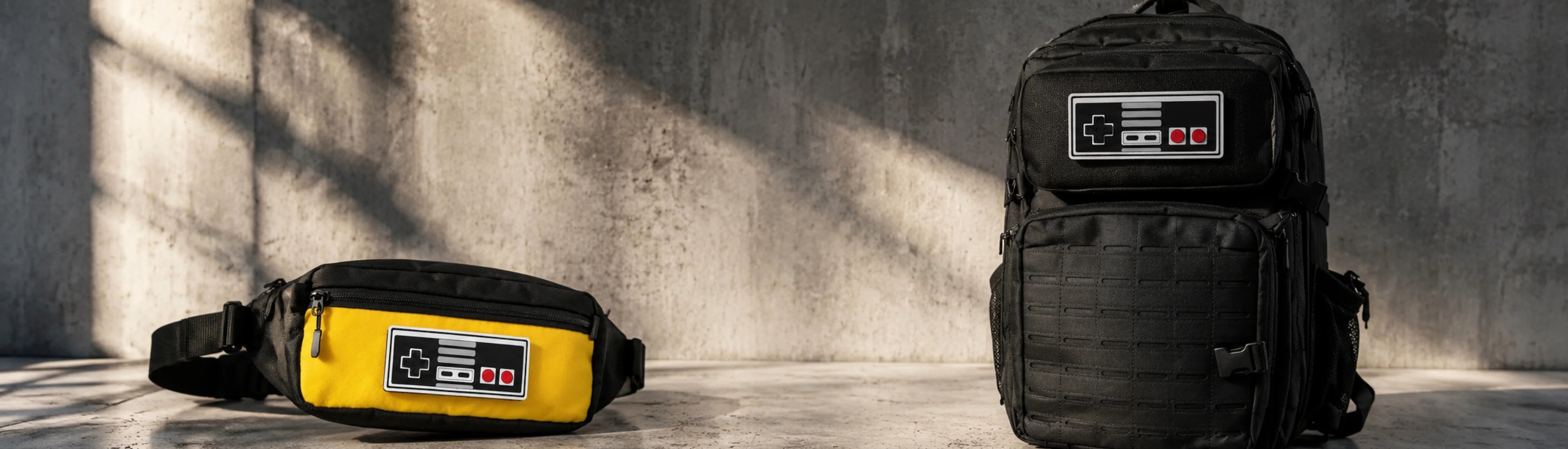 Black backpack and yellow waist bag with console design on a concrete floor.
