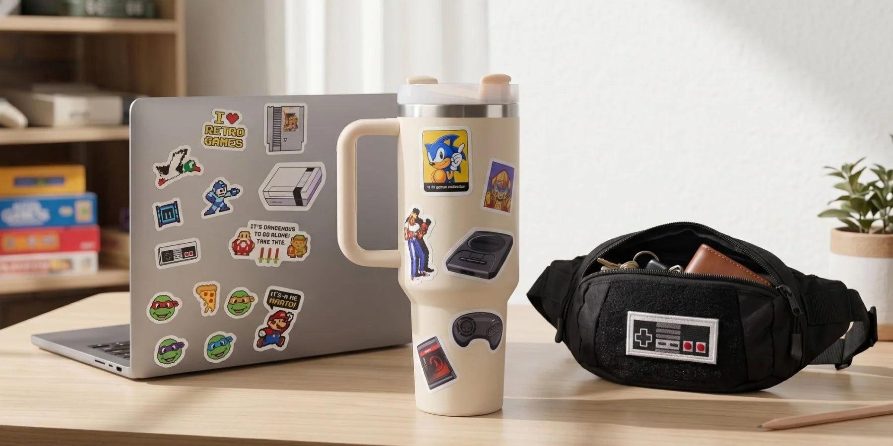 Laptop with stickers, mug with handle, and waist bag on a desk.