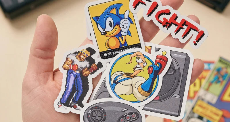 Hand holding a collection of retro-themed stickers featuring characters and gaming elements.